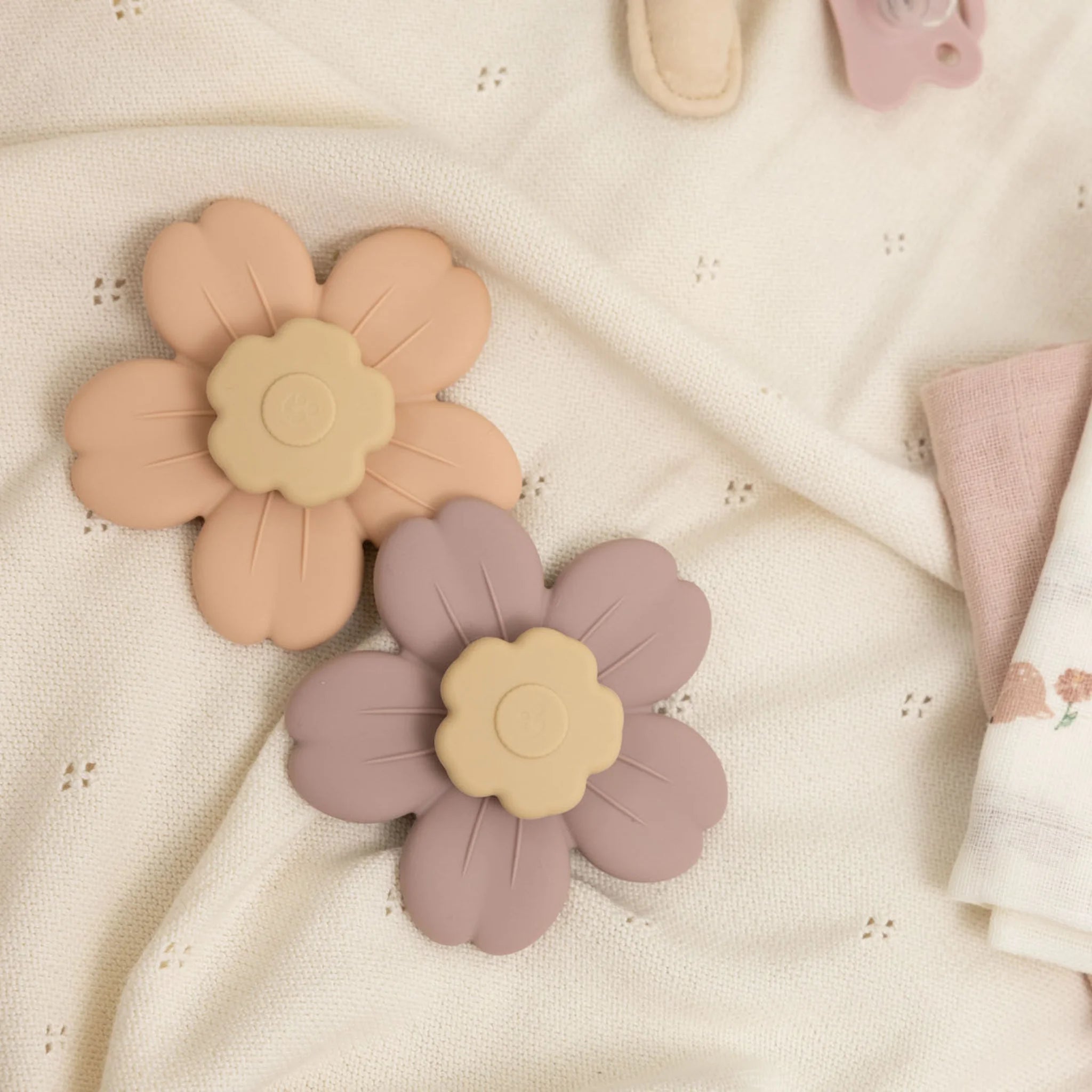 Twee Flower Spinners van Mom Glowth in roze en lila op zachte babydeken – sensorisch speelgoed van food-grade siliconen, BPA-vrij, vanaf 6 maanden