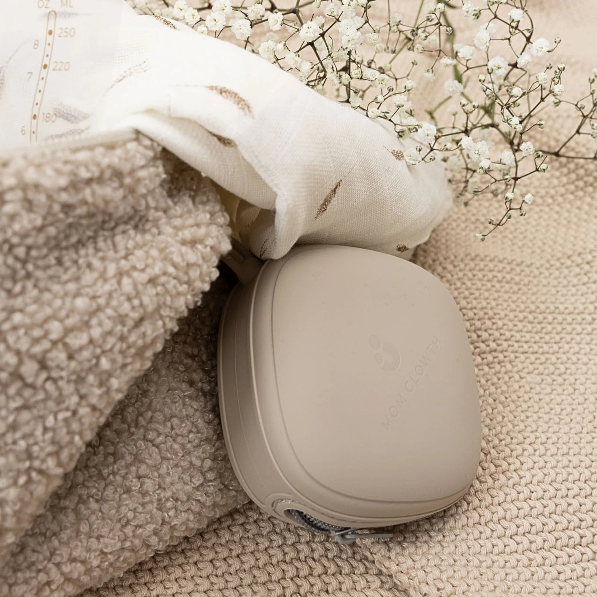 Siliconen fopspeenhouder van Mom Glowth in taupe, opgepakt van jute ondergrond – compact, BPA-vrij, ideaal voor onderweg aan luiertas.