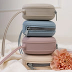 Siliconen fopspeenhouders van Mom Glowth in vier kleuren kiezelbeige, etherblauw, lila en nude beige gestapeld – BPA-vrij, food-grade siliconen, compact met rits