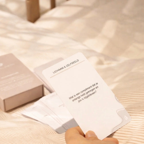 Hand houdt postpartum gesprekskaart van Mom Glowth vast met thema Lichaam en Zelfbeeld – set van 50 kaarten voor het vierde trimester