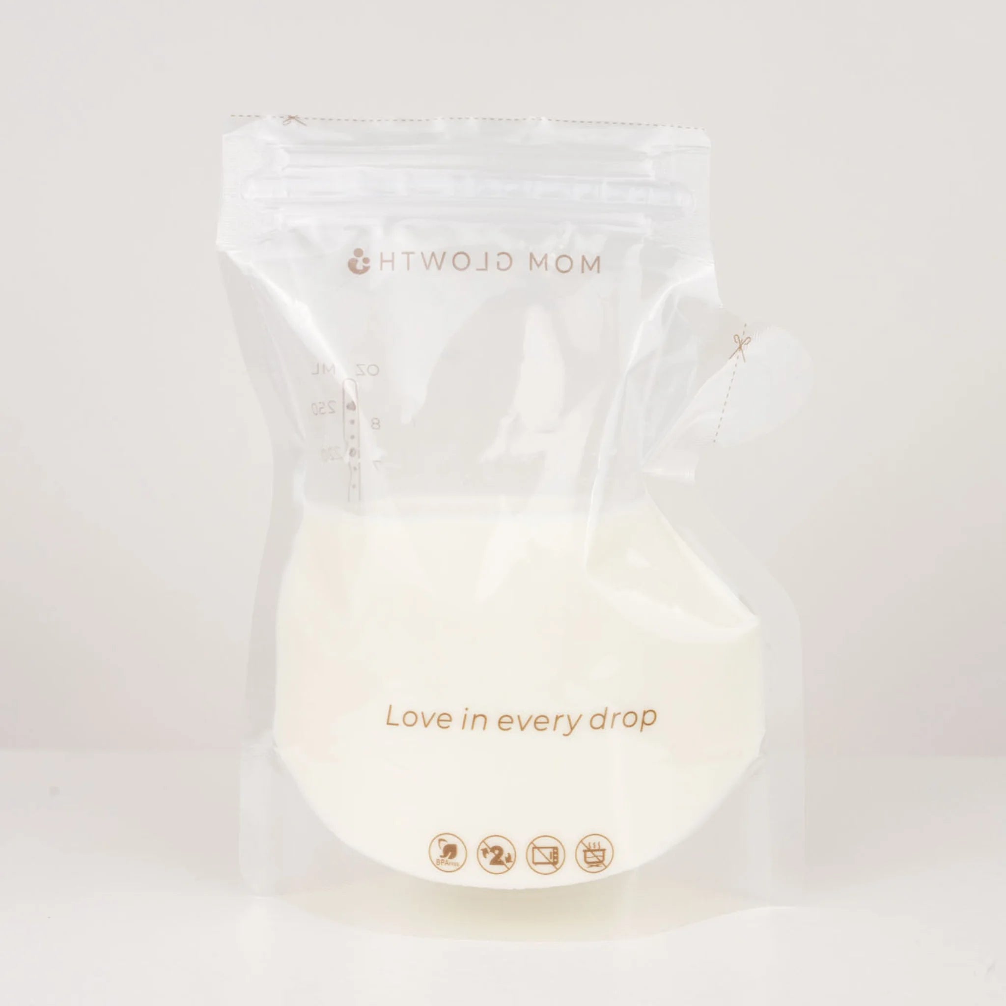 Gevuld moedermelk bewaarzakje van Mom Glowth met tekst Love in every drop – BPA-vrij, dubbele lekvrije sluiting, geschikt voor koelkast en vriezer